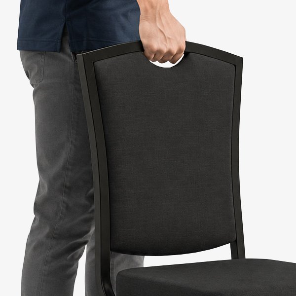 Person lifting banquet chair using integrated handhold in chair back