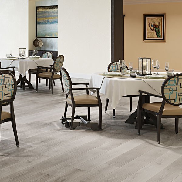 Hospitality dining room featuring commercial chairs equipped with Chair Caddie mobility units.